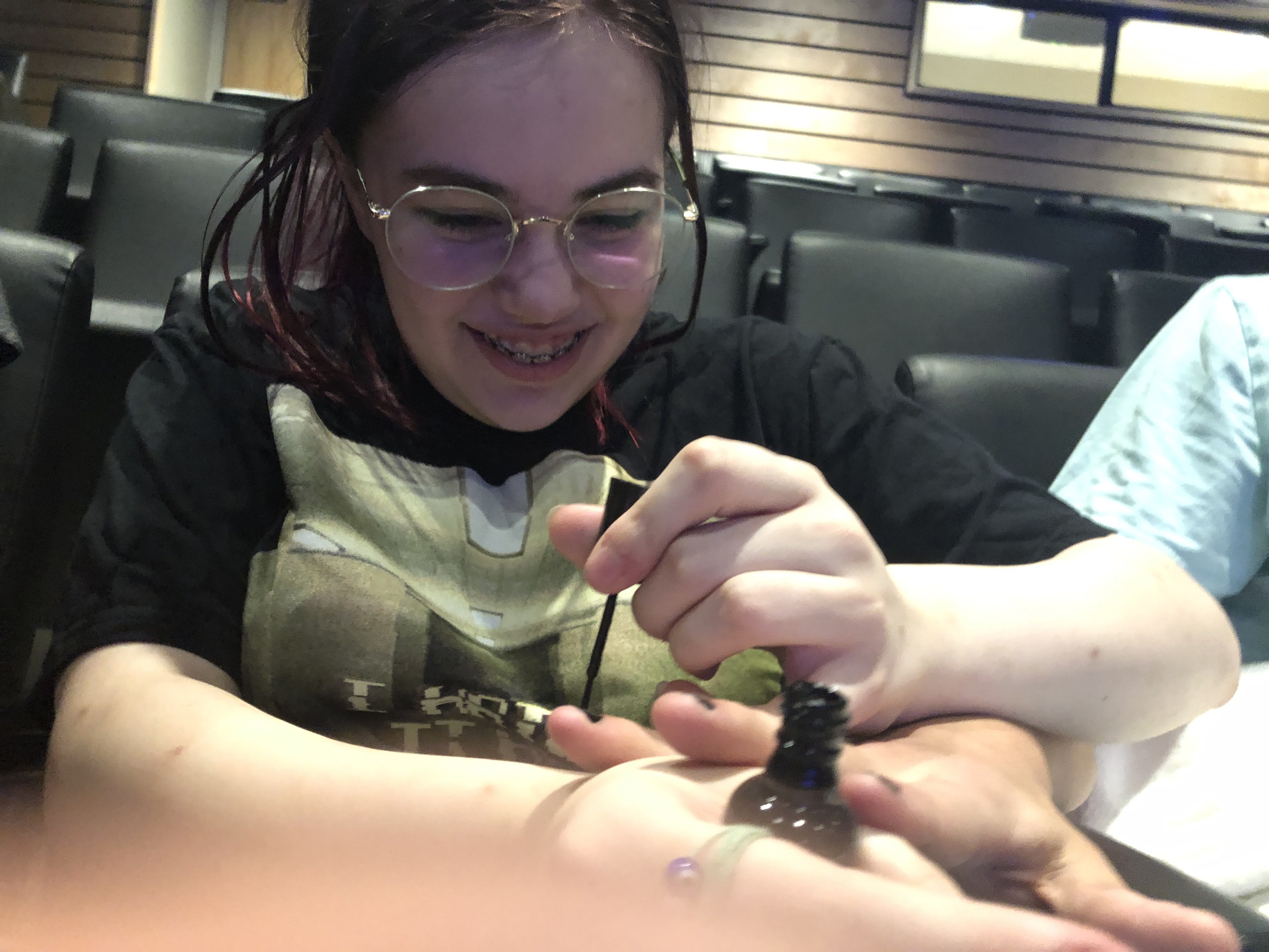 Scout painting Jacob's fingernails, laughing.